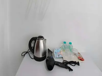 a counter with a coffee maker and bottles of water at xx The Hidden Khaosan Road เดอะ ฮิดเด้น ถนนข้าวสาร - รามบุตรี in Bang Bua Thong Railway Station