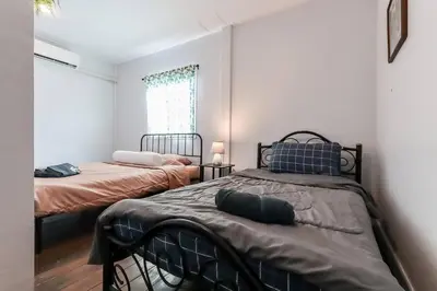 a bedroom with two beds and a window at Charming 2-Storey House in Bang Son, Bangkok in Bangkok