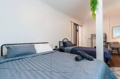 a bedroom with a bed with a blue comforter at Charming 2-Storey House in Bang Son, Bangkok in Bangkok