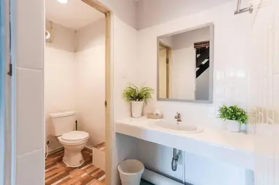 a white bathroom with a toilet and a sink at Charming 2-Storey House in Bang Son, Bangkok in Bangkok