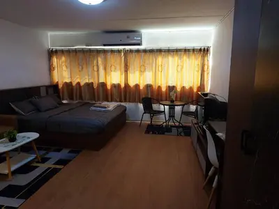 a living room with a bed and a table in it at Popular Muang Thong C5 in Thung Si Kan