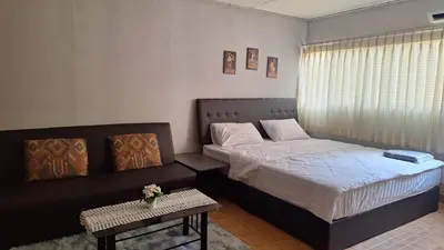 a bedroom with a bed and a side table at Popular Muang Thong C5 in Thung Si Kan