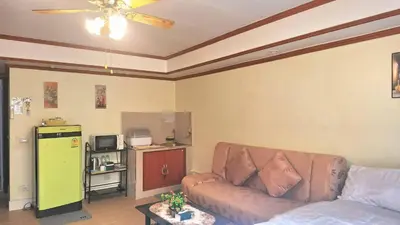 a living room with a couch and a ceiling fan at Popular Muang Thong C5 in Thung Si Kan