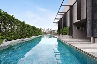 a swimming pool next to a building at BTS Thong Lor Downtown Low-rise Large Studio #Private Courtyard Super Large Pool in Bangkok