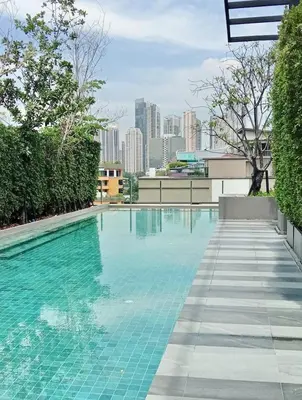 a swimming pool with a city skyline in the background at BTS Thong Lor Downtown Low-rise Large Studio #Private Courtyard Super Large Pool in Bangkok