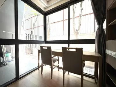 a dining room with a table and chairs in front of a window at BTS Thong Lor Downtown Low-rise Large Studio #Private Courtyard Super Large Pool in Bangkok