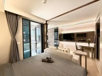a bedroom with a large bed and a living room at BTS Thong Lor Downtown Low-rise Large Studio #Private Courtyard Super Large Pool in Bangkok