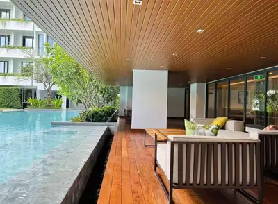 a house with a swimming pool with a couch and a swimming pool at Thonglor Central Low rise Condominium in Bangkok