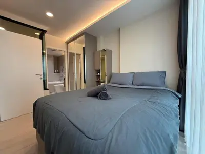 a bedroom with a large bed with blue sheets at Thonglor Central Low rise Condominium in Bangkok