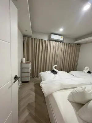a bedroom with two white beds and a window at Onsen Wellness Retreat House in Bangkok