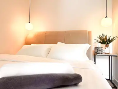 a bedroom with a white bed with two pendant lights at Onsen Wellness Retreat House in Bangkok