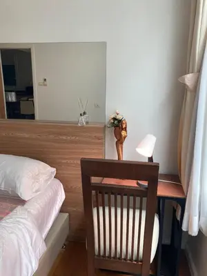 a bedroom with a bed and a desk with a lamp at 'City Retreat' Asok Sukhumvit 23 Room 53 sqm in Bangkok