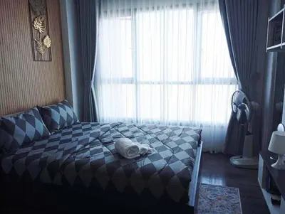a bed with a towel on it in front of a window at Octopus Suite on HighRise, Skytrain, Fast Wifi and AC in Amphoe Phra Khanong