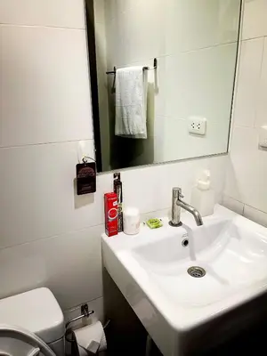 a bathroom with a sink and a mirror and a toilet at Octopus Suite on HighRise, Skytrain, Fast Wifi and AC in Amphoe Phra Khanong