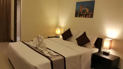 two beds in a hotel room with two lamps at Leelawadee Modern Resort Huaykwang - ลีลาวดี ห้วยขวาง in Bangkok