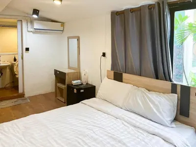 a bedroom with a white bed with a large window at Chubbi 5 Room1 in Ban Bang Bamru