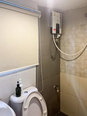 a small bathroom with a toilet and a shower at Chubbi 5 Room1 in Ban Bang Bamru