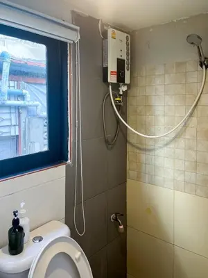 a small bathroom with a toilet and a shower at Chubbi 5 Room1 in Ban Bang Bamru