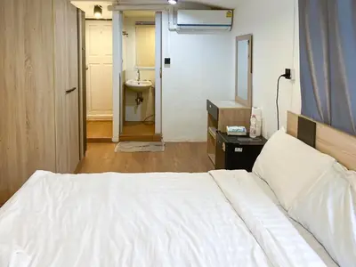 a bedroom with a bed and a bathroom with a sink at Chubbi 5 Room1 in Ban Bang Bamru