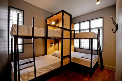 a room with three bunk beds in a house at Bangkok Bed and Bike in Bangkok