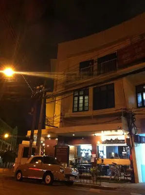 a car parked in front of a building at night at Bangkok Bed and Bike in Bangkok