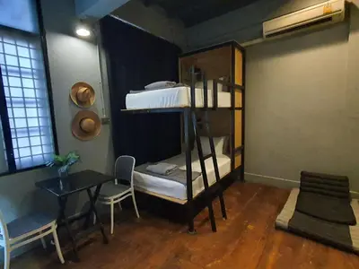 a room with a desk and a bunk bed and a table at Bangkok Bed and Bike in Bangkok