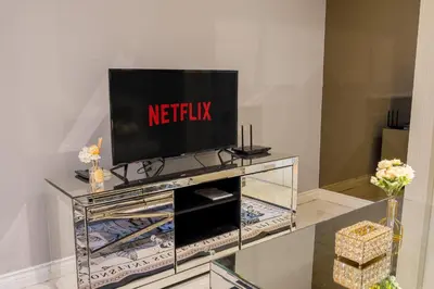 a television on top of a glass entertainment center at High-Floor City View Near SIAM in Bangkok