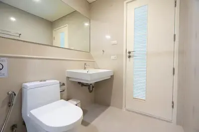 a bathroom with a toilet and a sink and a mirror at Ivy Thonglor Luxury Condo with Swimming Pool, Fast Wifi in Bangkok