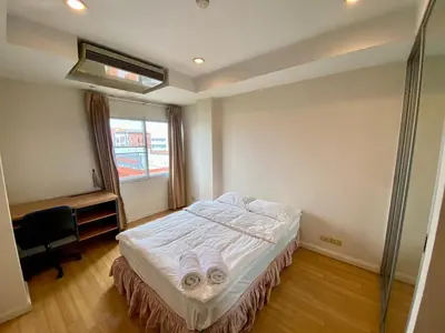a bedroom with a bed and a desk and a window at ศรีย่าน เรสซิเดนซ์ Sriyan Residence in Dusit