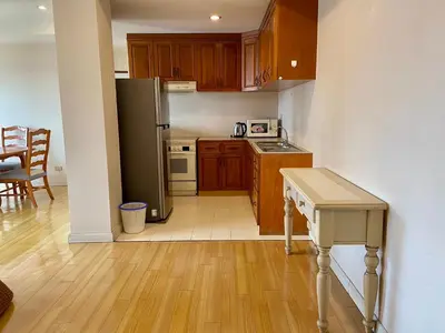 a kitchen with a refrigerator and a table in it at ศรีย่าน เรสซิเดนซ์ Sriyan Residence in Dusit