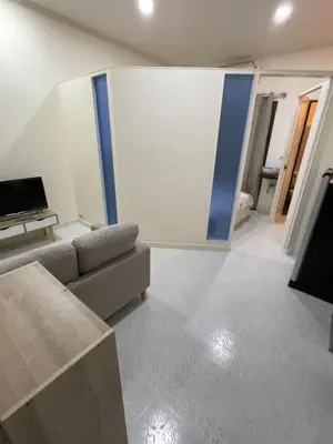 a living room with a couch and a tv at Sairin 1 bedroom BTS Udomsuk in Bangna