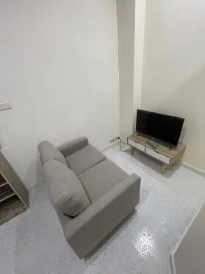 a living room with a couch and a flat screen tv at Sairin 1 bedroom BTS Udomsuk in Bangna