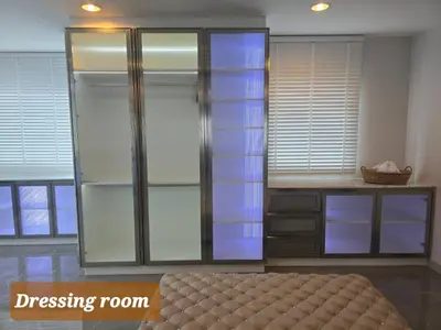 a bedroom with a dressing room with glass doors at Elegant Home near MRT Central WestGate and Central WestVille 3 to 10 Min Drive