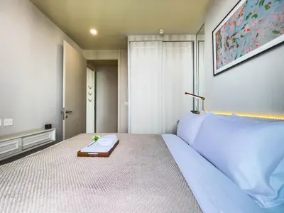 a bedroom with a white bed with a tray on it at CBD Living 2 BR ︱Prime Sukhumvit ︱Walk to BTS Asok & MRT SKV ︱UltraWi-Fi in Bangkok