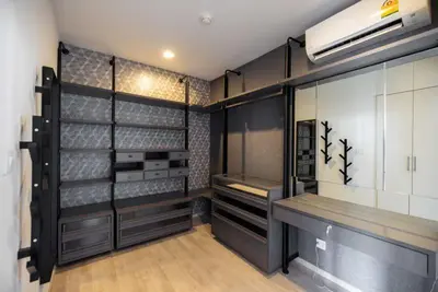 a walk in closet with black and white cabinets at Chambers cher ratchada ramintra in Ban Baen Phichit