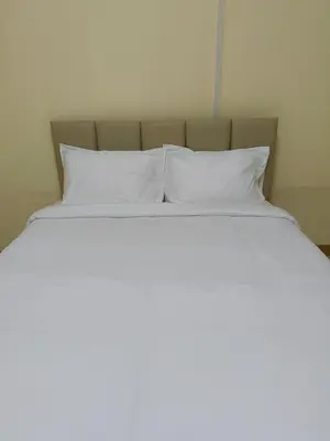 a bed with white pillows on top of it at UOKResort in Ban Khlong Yuan
