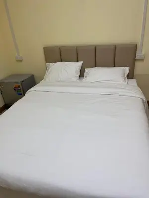 a large bed with white sheets and pillows at UOKResort in Ban Khlong Yuan