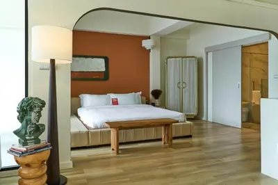 a bedroom with a bed and a table and a lamp at 5loft Anti-Hotel, Silom, Bangkok in Bangkok