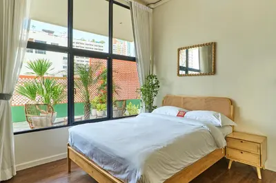 a bedroom with a bed and a large window at 5loft Anti-Hotel, Silom, Bangkok in Bangkok