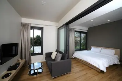 a bedroom with a bed and a couch and a tv at Bangkok Tryp in Bangkok