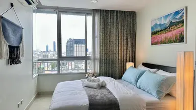 a bedroom with a bed with a large window at The Station Condo1 in Bangkok