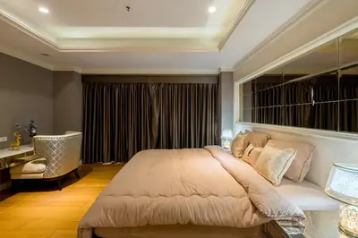 a bedroom with a large bed and a chair at State tower High Floor City View Lovely Unit in Bangkok