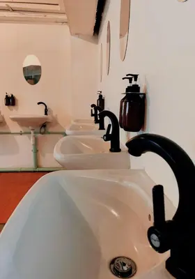 a bathroom with three sinks and two faucets at The Hide Out Rambuttri Hostel in Bang Bua Thong Railway Station