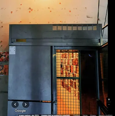 a stove top oven in a kitchen with a window at The Hide Out Rambuttri Hostel in Bang Bua Thong Railway Station