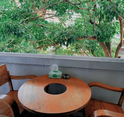 a wooden table with a tissue box on top of it at The Hide Out Rambuttri Hostel in Bang Bua Thong Railway Station