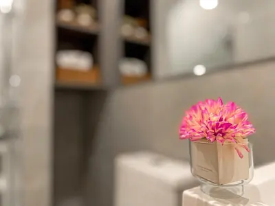 a pink flower in a glass vase on a counter at Luxury 2BR︱Fast WiFi︱Walk to Central & MRT Rama 9 in Bangkok