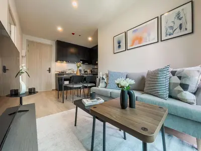 a living room with a blue couch and a table at Luxury 2BR︱Fast WiFi︱Walk to Central & MRT Rama 9 in Bangkok