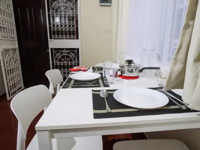 a white table with white plates on top of it at Cozy House 2BR BTS Ekkamai in Bangkok