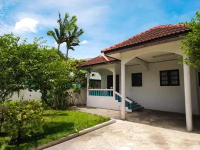 a small white house with a palm tree at Cozy House 2BR BTS Ekkamai in Bangkok