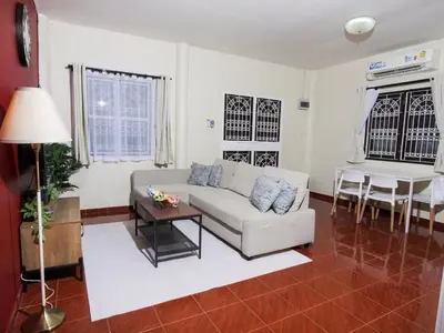 a living room with a couch and a table at Cozy House 2BR BTS Ekkamai in Bangkok